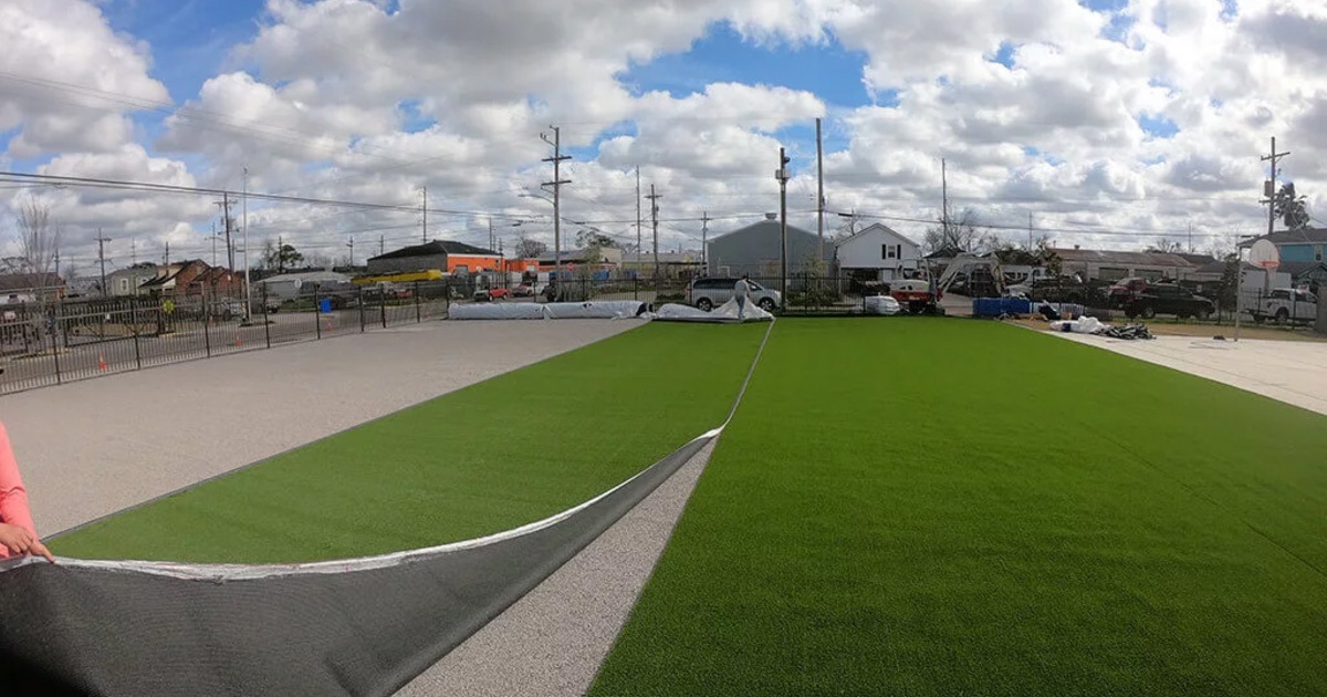 men installing the artificial turf on a playground FusionTurf