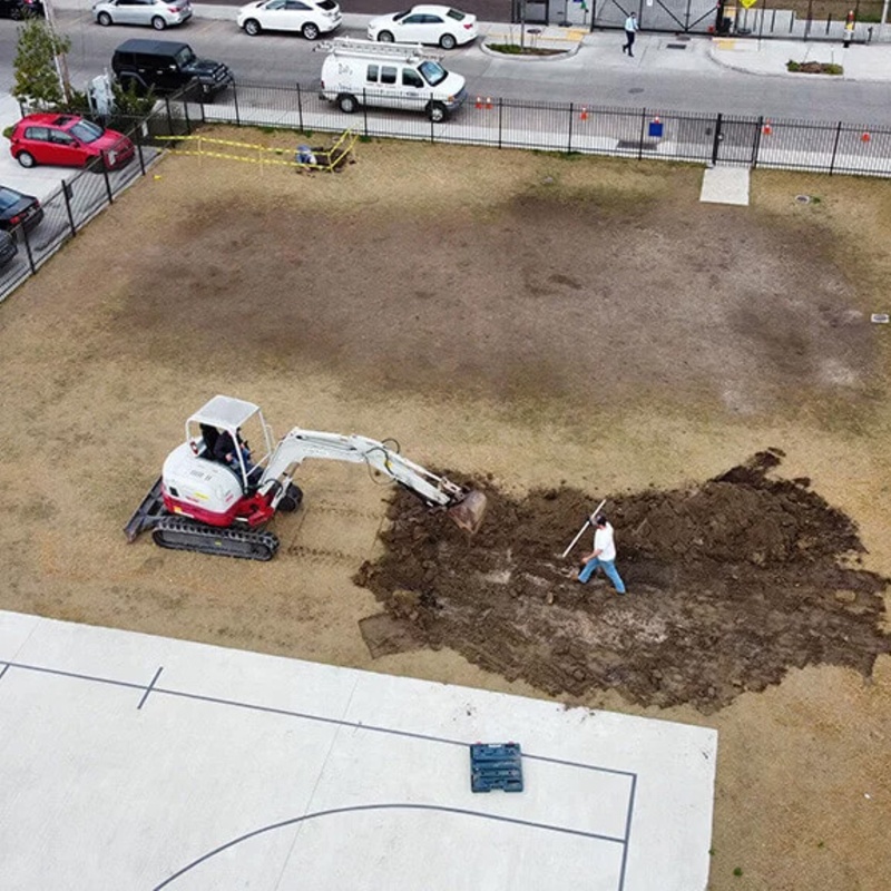 workers preparing playground to install artificial grass